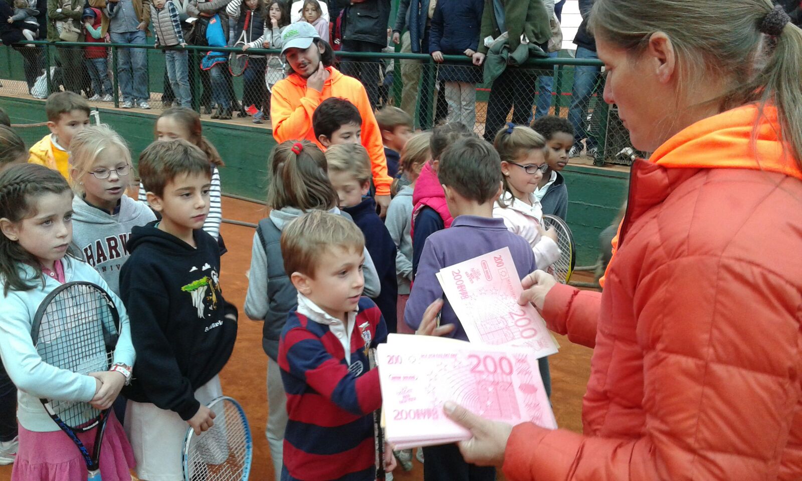 Una de las profesoras de la escuela repartiendo premios "en metálico" a los participantes.